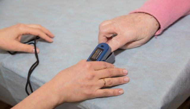 What does a pulse oximeter measure and how does it work?